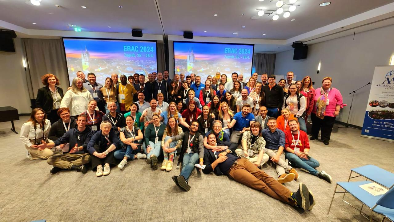 Group photo of alumni in front of the ERAC 2024 Zagreb screens