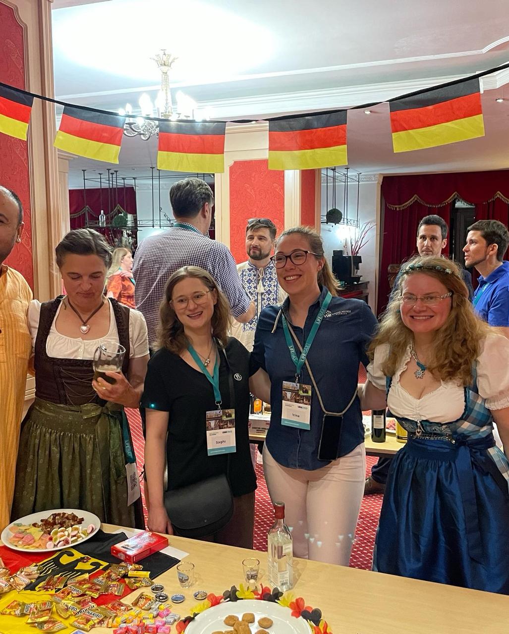 Alumni in dirndls at the German Global Village table with snacks and drinks